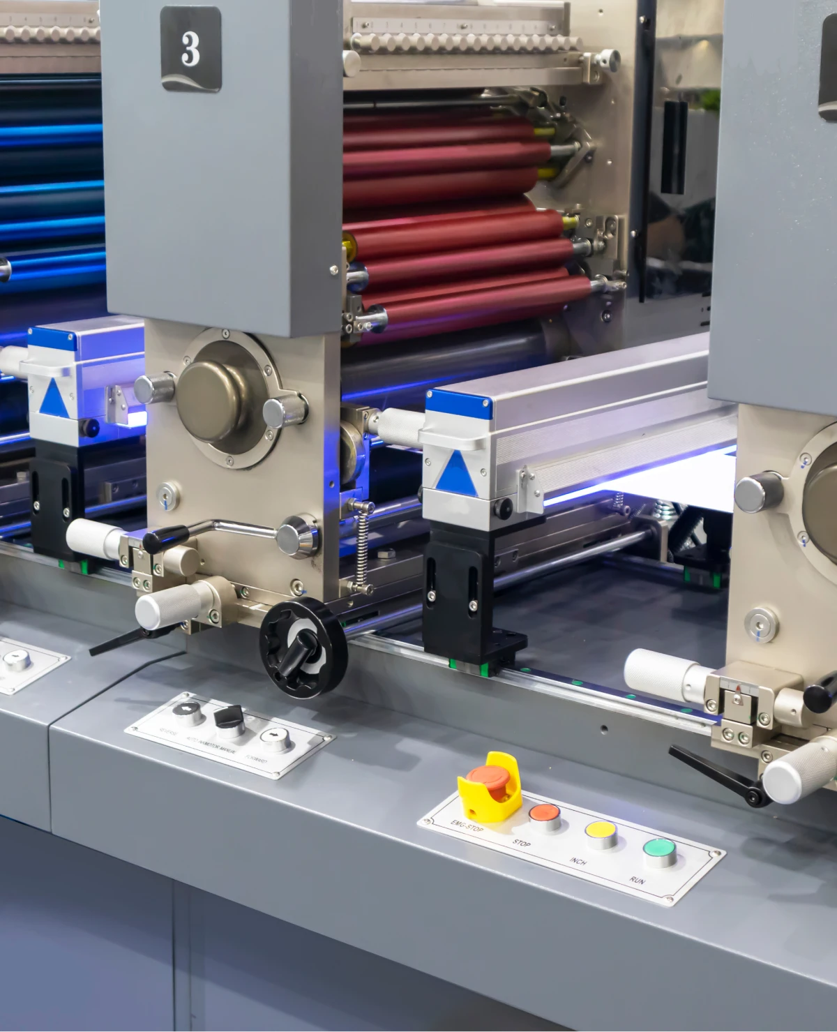 Printing machine with colorful rollers and controls.