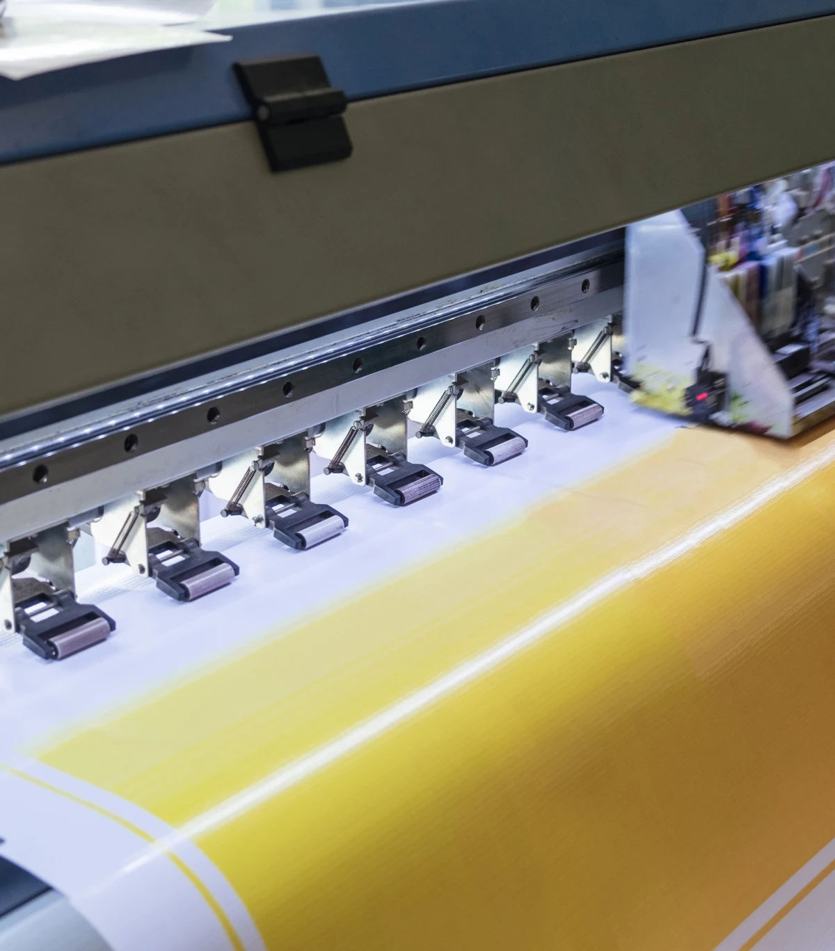 Large format printer printing yellow material.